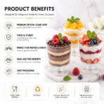 Set of four clear dessert cups filled with layered cream, sponge cake, and fresh fruits like strawberries, grapes, and mango on a marble tray.